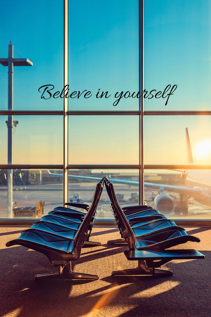 two chairs facing each other in front of an airport window with the words, believe in yourself