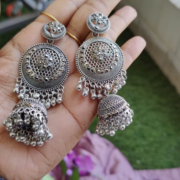 Elevate your jewelry collection with these stunning Oxidized Silver Jhumka Earrings, inspired by traditional Kashmiri craftsmanship. Handcrafted with meticulous attention to detail, these earrings feature intricate floral motifs and exquisite filigree work that perfectly captures the essence of Indian heritage. The large circular design is complemented by delicate ghungroo bells, adding a playful jingle with every movement. Ideal for festive occasions, weddings, and casual outings, these stateme Bridal Earrings With Latkans For Gift, Temple Jewelry Danglers As Gift, Festive Bohemian Jhumkas, Gift Danglers For Navratri, Chandbali Earrings With Latkans, Temple Jewelry Festival Earrings With Latkans, Diwali Drop Earrings Danglers, Silver Bridal Earrings For Navratri Gift, Navratri Drop Danglers