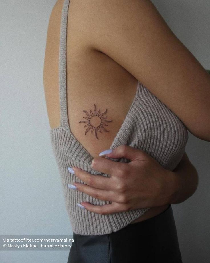 a woman with a sun tattoo on her shoulder