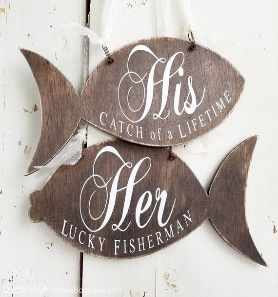 two wooden signs that say fish, catch of a life time and be lucky fisherman