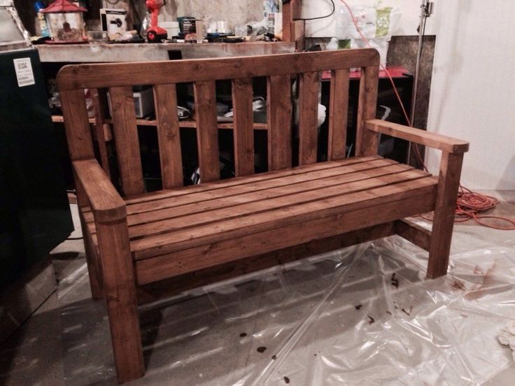 a wooden bench sitting on top of a plastic covered floor