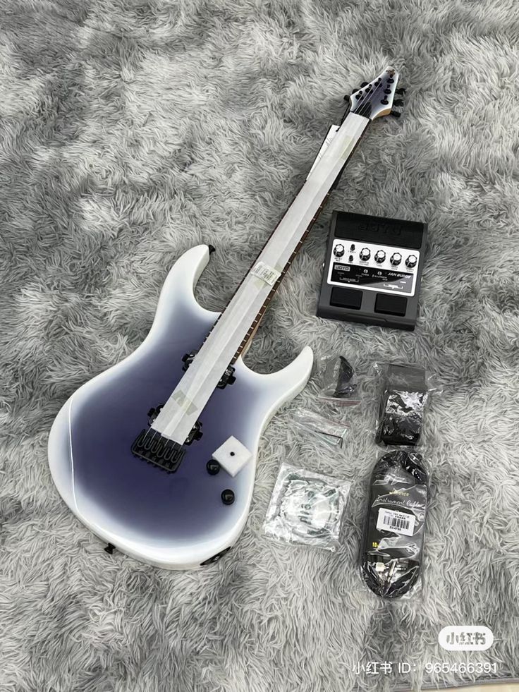 an electric guitar laying on top of a carpet next to other items and accessories in plastic bags