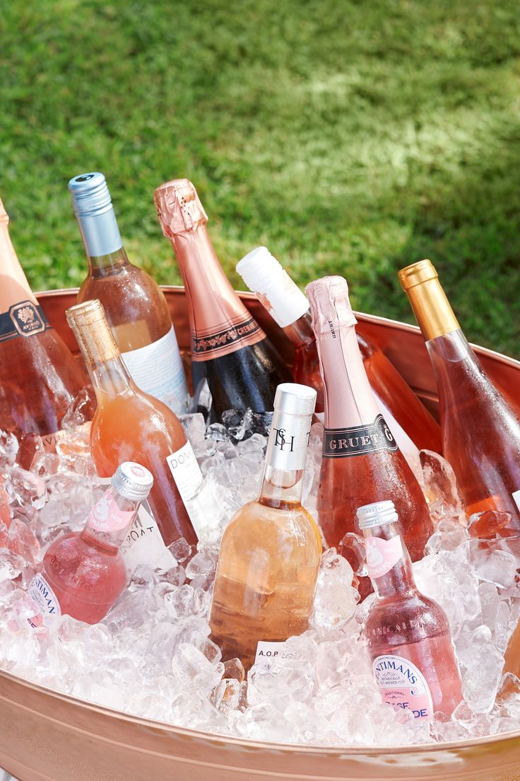 a bucket filled with lots of bottles of wine and ice on top of a table