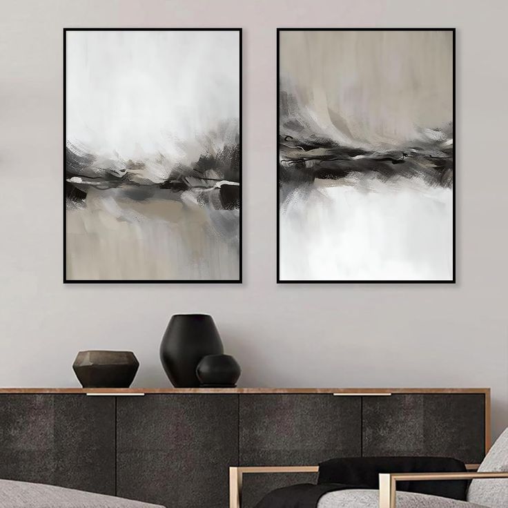 two black and white paintings in a living room