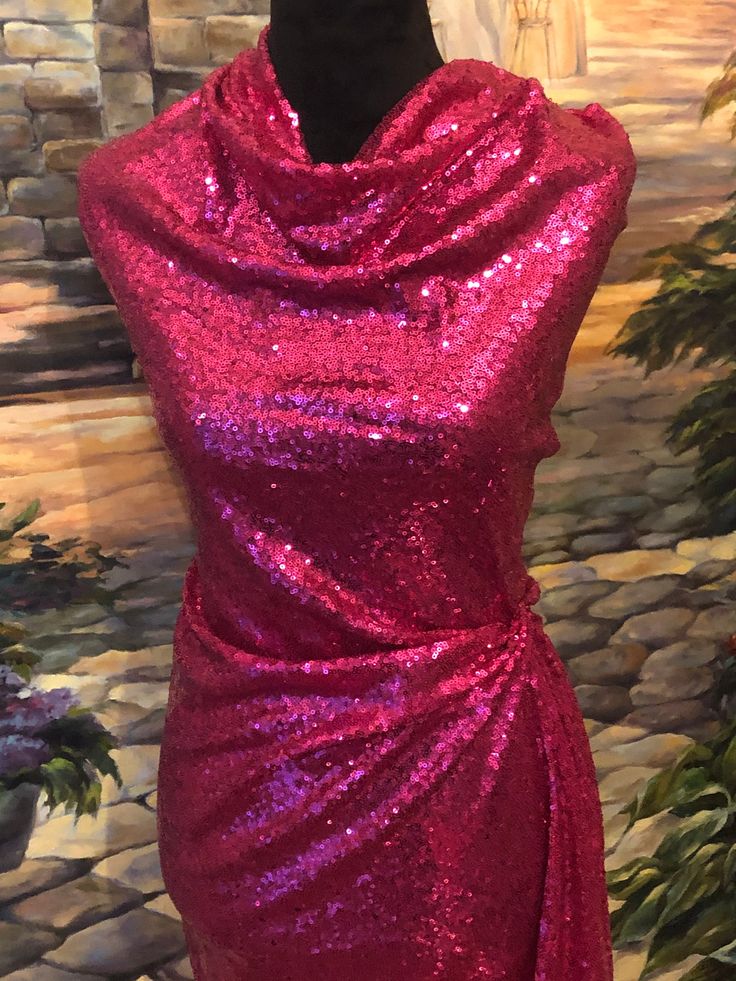 a red dress on display in front of a brick wall