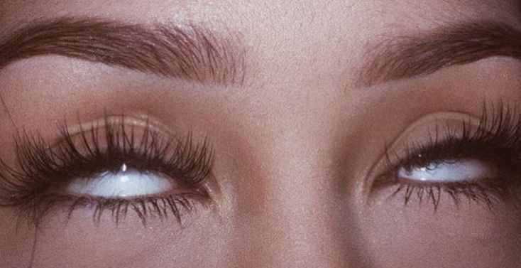 a close up shot of a woman's eye with long lashes