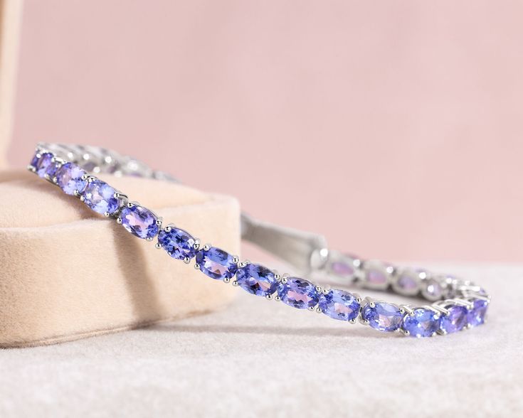 "✨ ITEM DETAILS Metal: 14K White Gold Weight: 12.59  Certificate: GEL Total Carat Weight:  15.62 Note: Contact us for Resizing   ✨  MAIN STONE Gemstone:  Tanzanite  Shape: Oval  Gemstone Amount:  30  Carat Weight:  15.62  Color:  Purplish-Blue  Clarity:  Transparent  Creation Method: Natural Commonly Treated   ✨RETURN & EXCHANGE: * No Hassle, Full refund or exchange within 30 days of receipt of purchase. Please contact me within 14 days upon receipt of item. * Item must be in new condition with no dents or scratches. * For Custom Orders, No Return/Exchange.  ✨ SHIPPING * Free Shipping and Free Certificate with every order, fully certified and appraised via GEL, a well-known laboratory.  ✨ EXTRAS: * All jewelry comes in a luxurious gift box, ready to be given as a gift for your loved ones, Luxury Oval Tennis Bracelet As Gift, Oval Gemstone Tennis Bracelet For Anniversary, Gemstone Accented Fine Jewelry Tennis Bracelet, White Gold Oval Tennis Bracelet Gift, Oval Gemstone Bracelets For Anniversary, Oval Gemstone Accent Bracelets For Anniversary, Oval Anniversary Bracelets With Gemstone Accents, Oval Bracelets With Gemstone Accents For Anniversary, Tanzanite Gemstone Bracelet For Anniversary