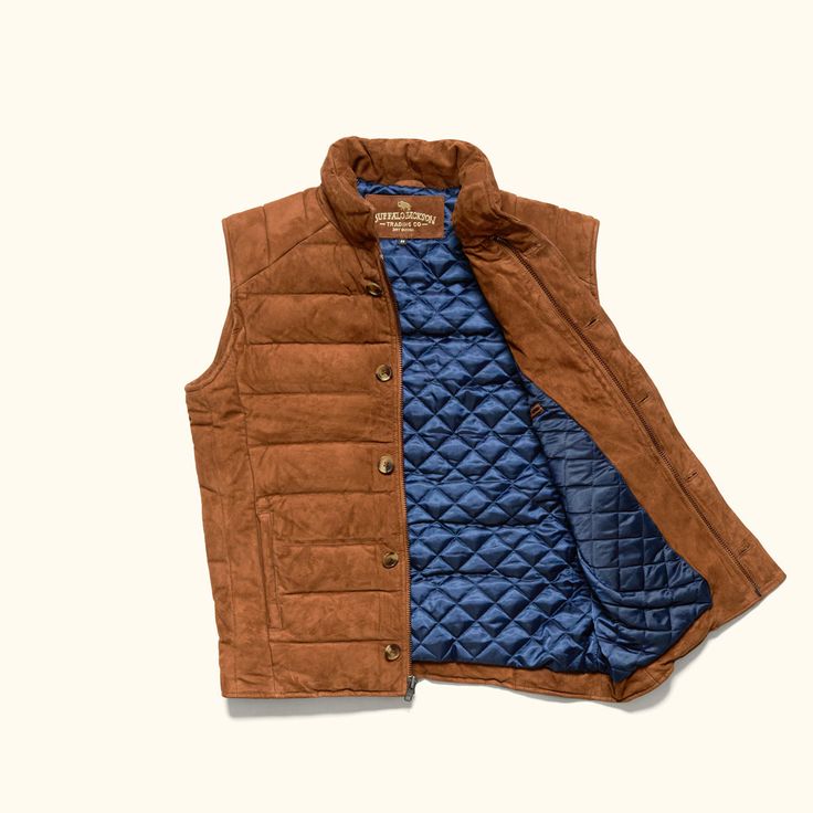 Crafted from lambskin, our suede leather Jackson Vest combines refined texture with rugged functionality. The ultra-soft suede exterior is paired with two front pockets and interior zippered pocket. The vest is lined with a navy twill polyester quilted fabric, adding a subtle contrast while enhancing comfort and durability. Designed for warmth without the bulk, the vest features premium down fill to shield you from the cold in the mountain air. The combination of lamb suede and down insulation e Outdoor Leather Vest With Pockets, Leather Winter Outdoor Vest, Outdoor Brown Leather Vest, Leather Winter Vest With Pockets, Mens Outdoor Vest, Waxed Canvas Jacket, Dark Brown Leather Jacket, Leather Camera Bag, Leather Jacket Style