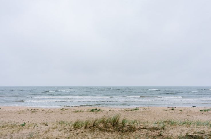 an empty beach with the ocean in the background