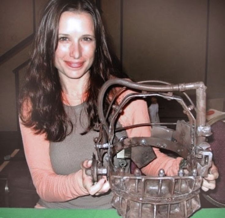 a woman is holding an old machine in her hands