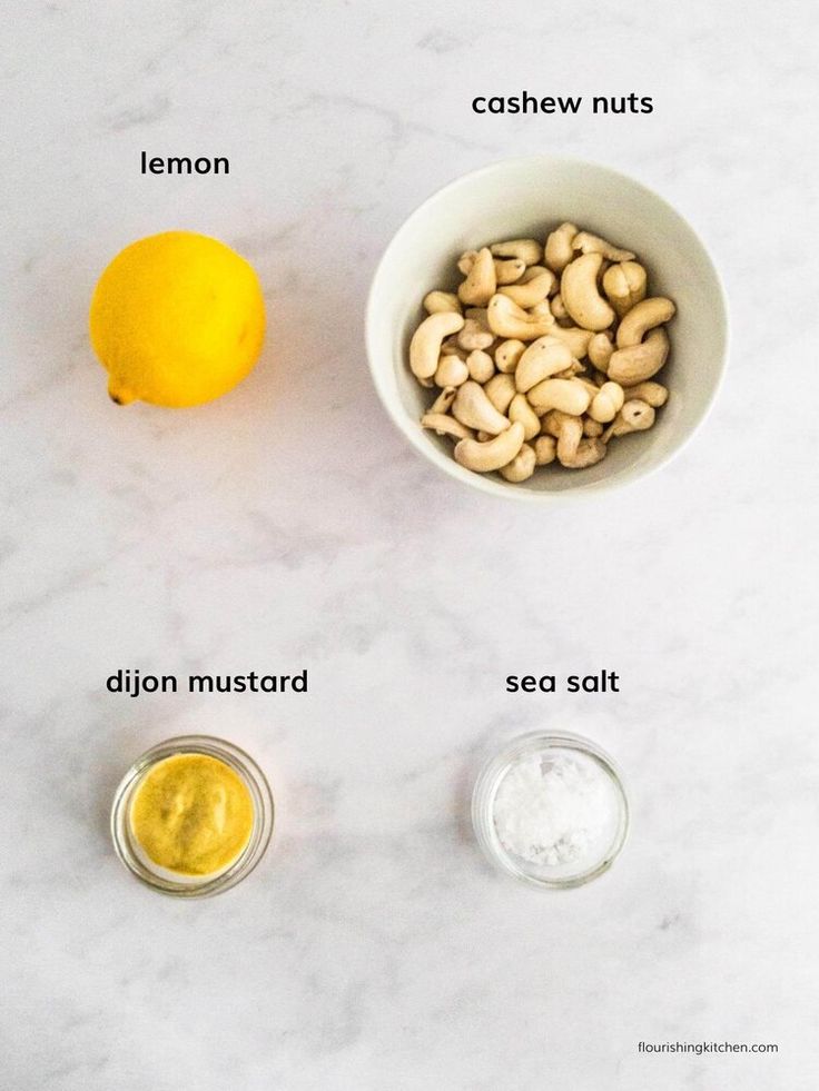 ingredients to make lemon cashews in small bowls on a white marble countertop