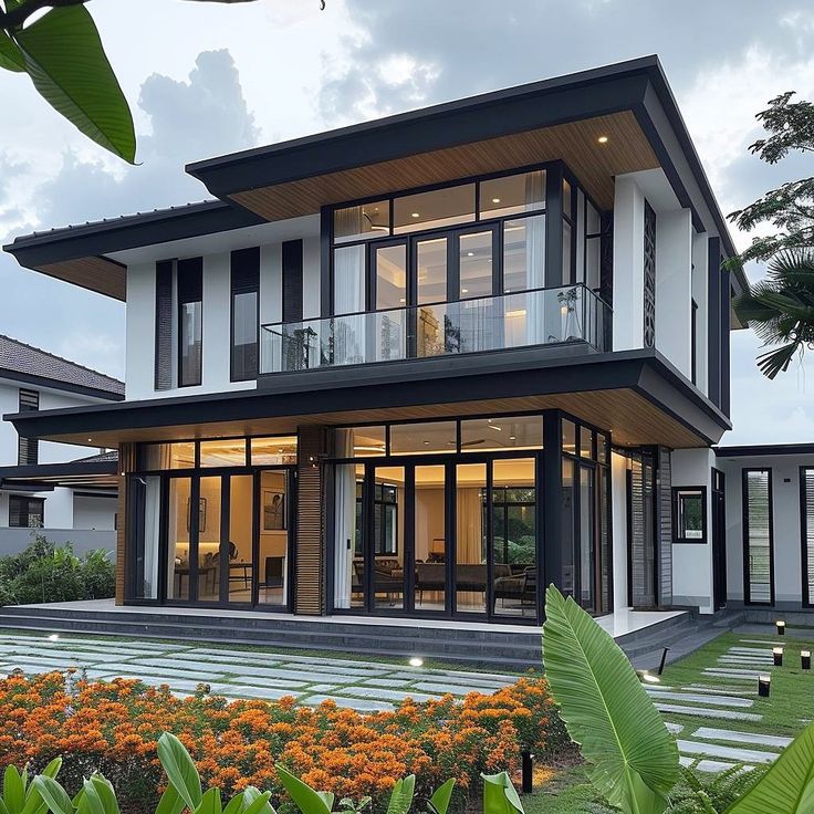 a large house with lots of windows and flowers in the front yard