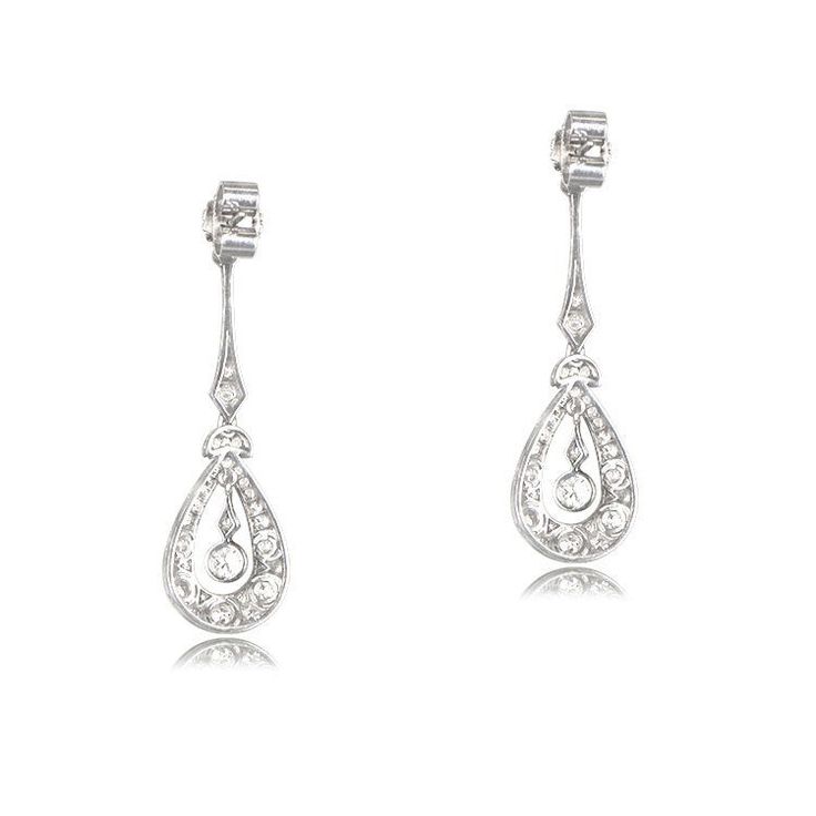 This lovely pair of earrings is Edwardian inspired, featuring intricate details in handcrafted platinum. Old mien cut diamonds are set along the drop of the earrings, surrounding the center diamond. The total approximate weight of these earrings is 2.00 carats. ✦ EARRING SPECIFICATIONS: Ring Material: Platinum Ring Era: Edwardian Era Stones: Diamond ✦ WHAT COMES IN YOUR SHIPMENT: - Your Engagement Ring - Quality Ring Box - Jewelry Cleaner - UGL Certificate ✦ WHY SHOP WITH US: - We've been in bus Art Deco Diamond Drop Earrings For Formal Occasions, Luxury Diamond Earrings With Intricate Design For Anniversary, Elegant Platinum Diamond Earrings, Exquisite Diamond Earrings With Intricate Design For Formal Occasions, Formal Pear-shaped Platinum Earrings, Art Deco Silver Diamond Earrings In Platinum, Silver Art Deco Platinum Diamond Earrings, Art Deco Platinum Earrings For Wedding, Hallmarked Platinum Diamond Earrings For Wedding