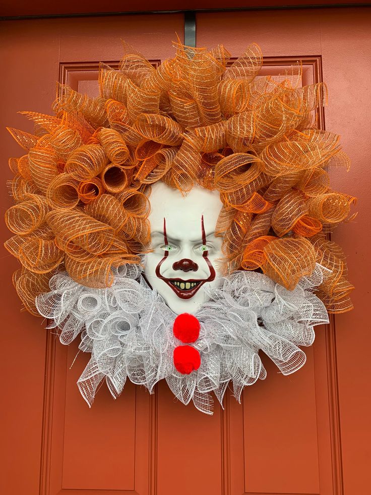 a creepy clown's head hanging on the front door of a house with curly hair