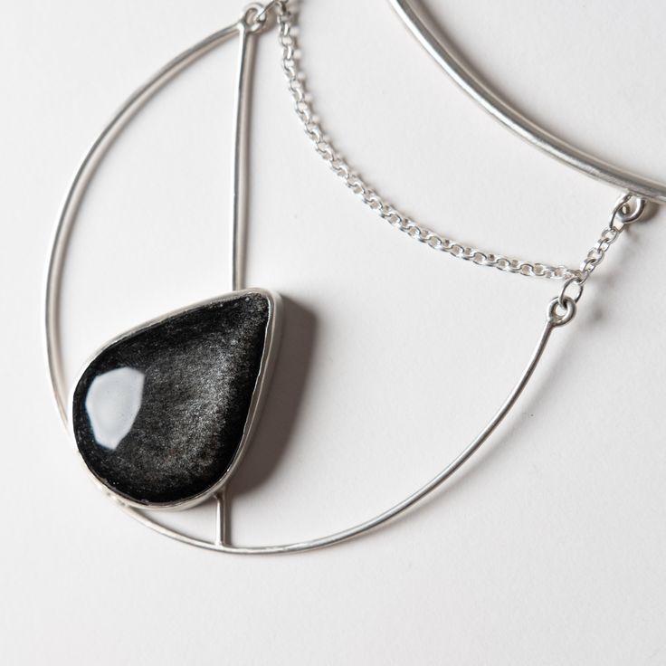 This one of a kind statement piece is hand fabricated in sterling silver, with a beautiful silver sheen obsidian. Collar size is slightly adjustable. Handcrafted in San Francisco. In stock and ready to ship. Silver Obsidian Necklaces, Silver Obsidian Pendant Necklace, Silver Obsidian Gemstone Necklace, Silver Obsidian Necklace With Natural Stones, Modern Jewelry With Large Stone Pendant, Modern Jewelry Pendant With Large Stone, Silver Onyx Necklace With Polished Finish, Modern Jewelry With Large Pendant Stone, Modern Silver Jewelry With Large Stone