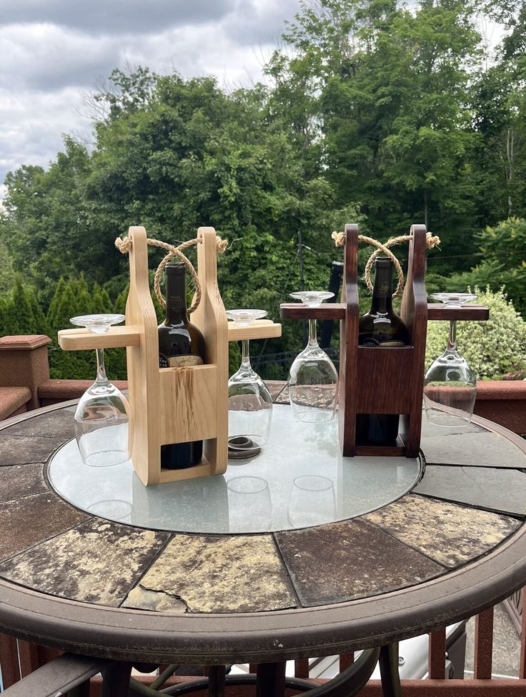 two wine glasses sitting on top of a table next to some bottles and glassware