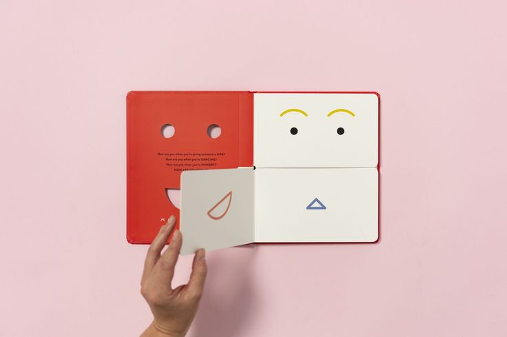 someone is holding an origami book in front of the other one with eyes and nose