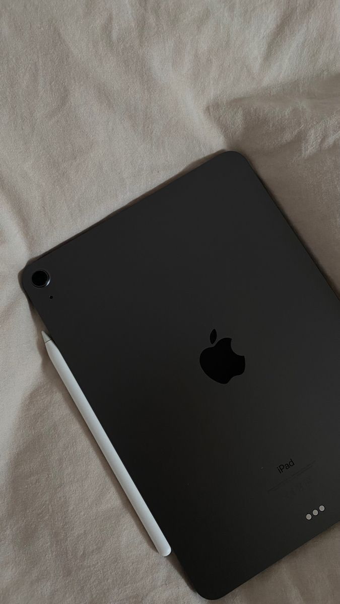 an apple ipad sitting on top of a white sheet covered in sheets and linens