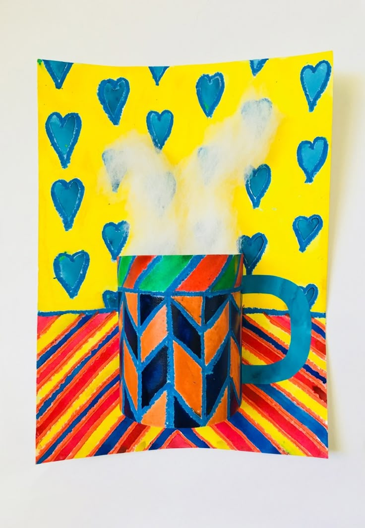 an art project made out of colored paper with blue hearts on the side and a cup in the middle