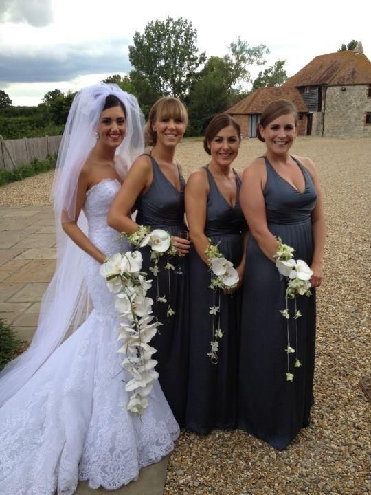 four bridesmaids pose for a photo in front of the barn at their wedding