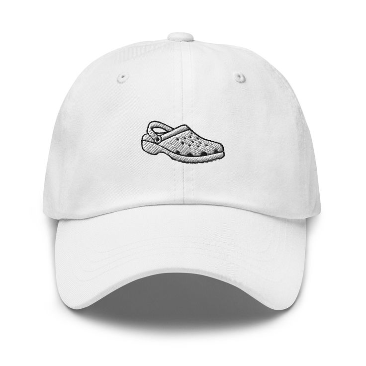 "Elevate your footwear fashion with our Croc Shoe Embroidered Cap. This unique cap features a detailed embroidery of the iconic Croc shoe design, making it a fun and distinctive addition to your collection. Crafted with precision and quality, this cap offers both style and comfort. Whether you're a Croc lover or simply seeking a quirky accessory, this cap is the perfect choice. Get your Croc Shoe Embroidered Cap today on Etsy to showcase your love for these unique shoes and make a bold fashion statement. Don't miss out on this stylish and one-of-a-kind cap! Dad hats aren't just for dads. This one's got a low profile with an adjustable strap and curved visor. * 100% chino cotton twill * Green Camo color is 35% chino cotton twill, 65% polyester * Unstructured, 6-panel, low-profile * 6 embroi Embroidered Baseball Cap With Visor For Streetwear, Embroidered Visor Baseball Cap For Streetwear, Streetwear Baseball Cap With Embroidered Logo, Casual Snapback Baseball Cap With Appliqué Logo, Casual Baseball Cap With Appliqué Logo, Casual Hat With Appliqué Logo And Curved Brim, Embroidered White Baseball Cap For Streetwear, Embroidered Dad Hat For Streetwear, Casual Trucker Hat With Custom Embroidery And Curved Brim