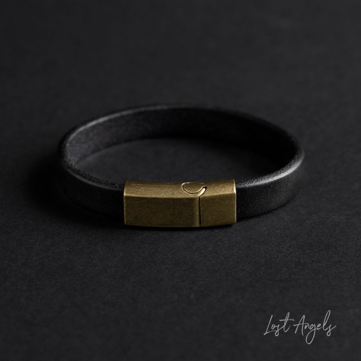 **NOTE: This item is available in TWO sizes. PLEASE ORDER THE MOST SUITABLE SIZE FOR YOUR WRIST** 100% Genuine leather BLACK band bracelet with brass slip buckle. Stylish design to complement both casual and smart outfits. Material: Genuine Leather. Brass Slip Buckle. Two Lengths available: (S/M)20cm  (M/L)22cm (Model has wrist size of 7.5inchs and wears a s/m) Width: 1.2cm This item comes complete with a gift pouch. Classic Gold Leather Bracelet For Everyday, Gold Modern Leather Bracelet For Everyday Wear, Modern Gold Leather Bracelet For Everyday, Gold Minimalist Leather Bracelet, Minimalist Gold Leather Bracelet, Adjustable Leather Bracelet With Gold Clasp, Gold Leather Bracelet With Brass Hardware, Masculine Everyday Jewelry With Leather Strap, Minimalist Leather Bracelets For Everyday Use