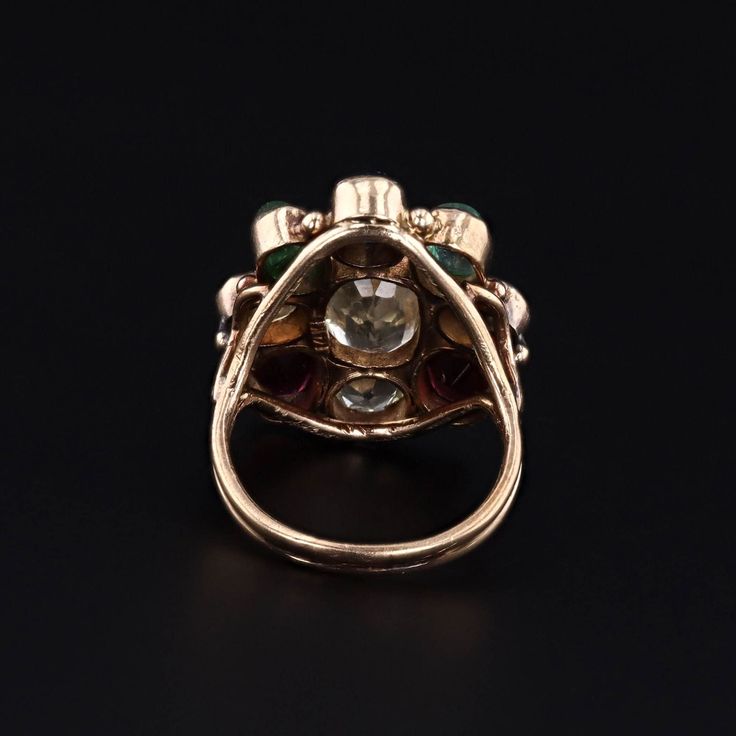 This vintage ring (circa 1960-1970) features assorted gemstones in 14k gold. The gemstones include garnet, zircon, emerald, sapphire, aquamarine, and chrysoberyl. The face of the ring measures 0.9 inches by 0.8 inches wide and is in very good condition with light surface wear. The ring is currently a size 6, but it can be resized free of charge. Materials: 14k gold, chrysoberyl, aquamarine, sapphire, emerald, zircon, garnet. Antique Multi-stone Round Emerald Ring, Antique Round Multi-stone Emerald Ring, Vintage Multi-stone Diamond Ring For Collectors, Vintage Multi-stone Diamond Ring Collectible, Vintage Multi-stone Ruby Ring In 14k Gold, Vintage Multi-stone Emerald Ring In 14k Gold, Vintage Multi-stone Sapphire Ring, Antique Green Multi-stone Ring, Heirloom Multi-stone Diamond Ring