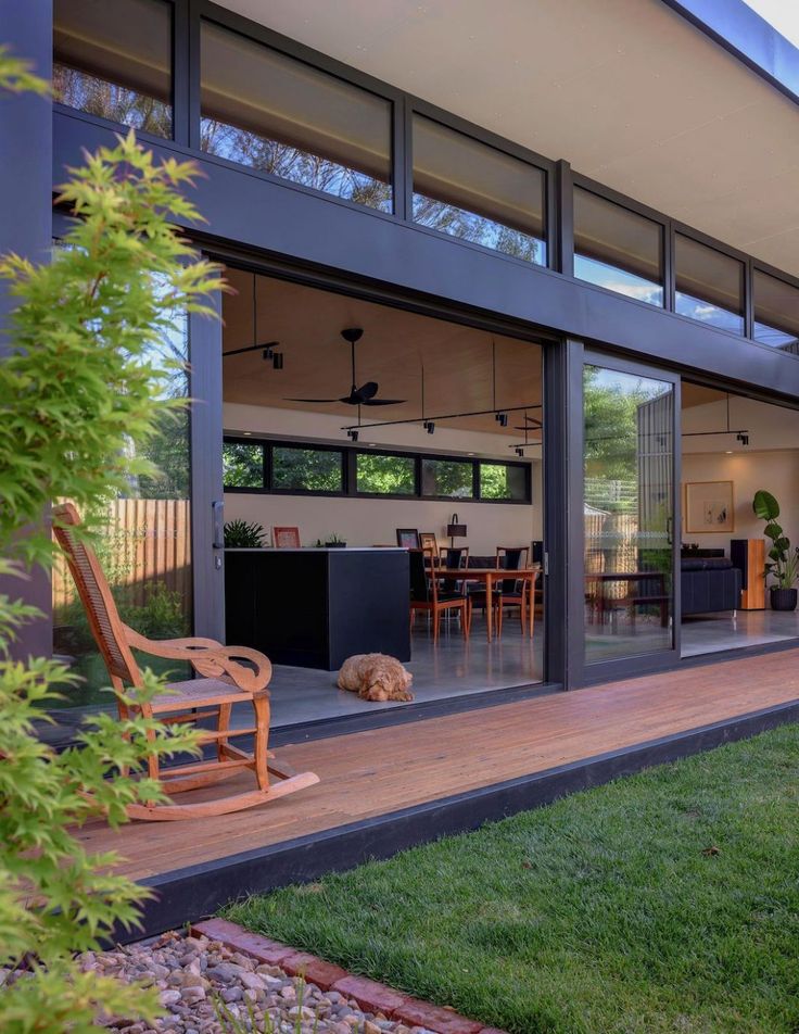 an open living room and dining area with sliding glass doors on the outside side of the house