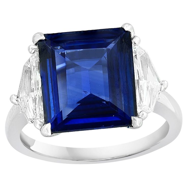 an emerald and diamond ring with blue sapphires