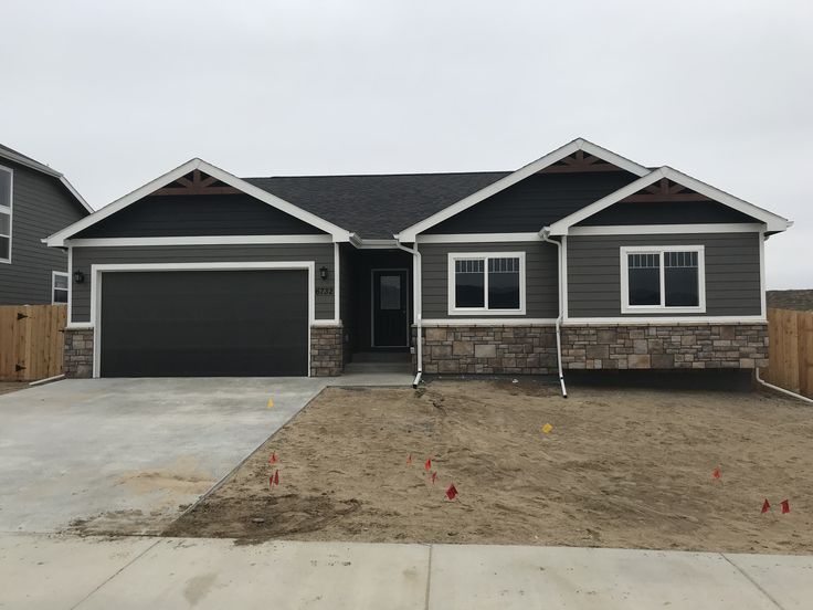 a gray house with two garages in the front and one on the other side