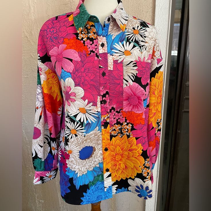 a colorful shirt is hanging on a mannequin's dummy stand in front of a wall