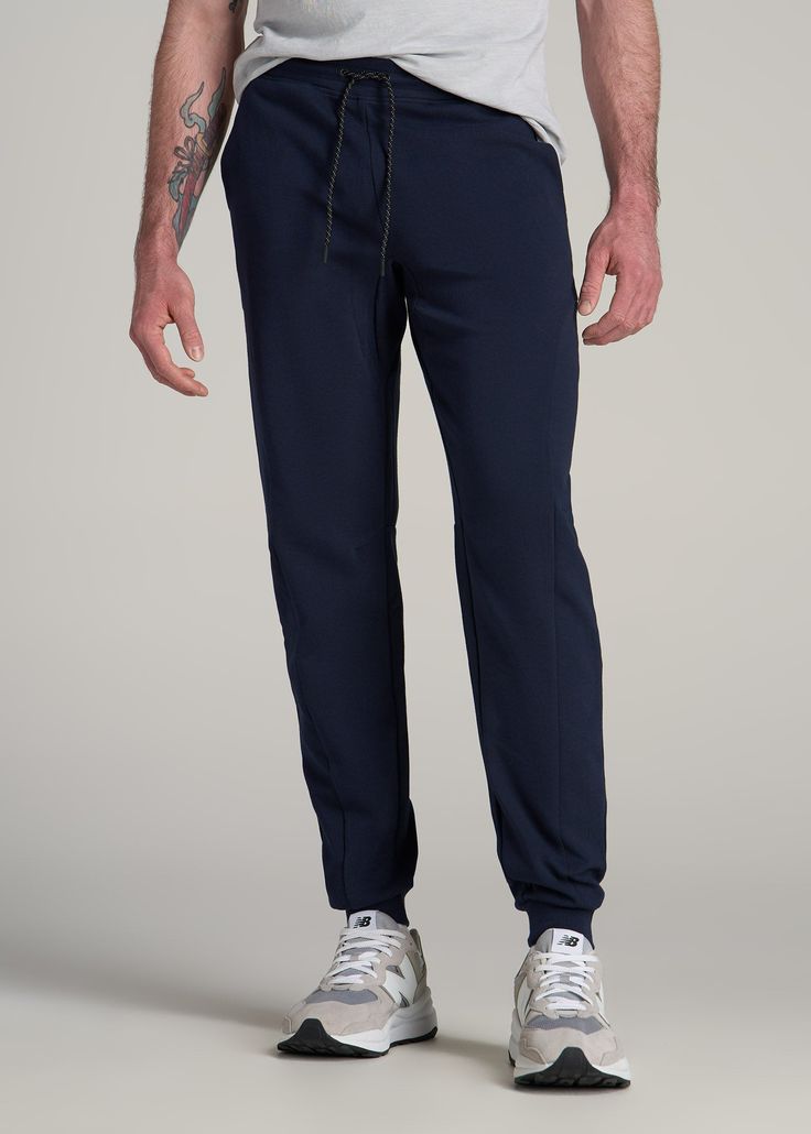 Discover the Ultimate Joggers for Tall Men Comfort Meets Utility in These Tall Men's Jogger Pants Our Utility Joggers redefine the standard for athletic pants. Designed for tall men, these extra-long men's joggers blend a modern fit with practical functionality, perfect for an active lifestyle or a relaxed day. They are the epitome of comfort and utility, tailored for those who are tall and seek style without compromise. Athletic jogger style with a modern fit Stretch fabric and waistband for ma Blue Sports Sweatpants With Elastic Side Panels, Navy Functional Workout Bottoms, Functional Moisture-wicking Tapered Leg Bottoms, Blue Workout Bottoms With Elastic Side Panels, Navy Sporty Joggers For The Gym, Sporty Navy Joggers For Gym, Functional Blue Training Bottoms, Blue Functional Training Bottoms, Navy Relaxed Fit Sweatpants For Sports