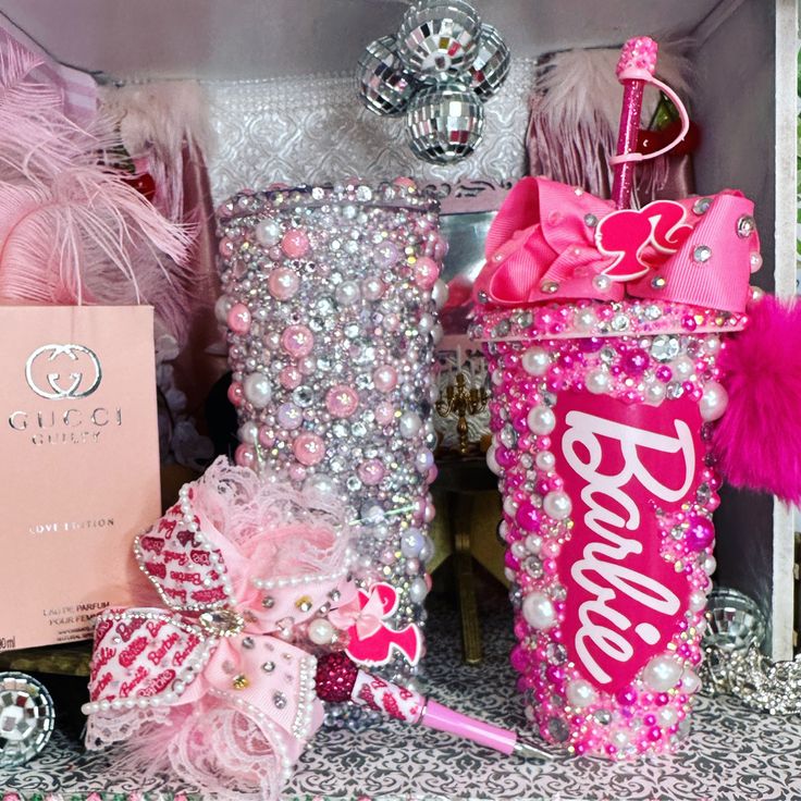 pink and silver items are on display in a box, with the word barbie written on it