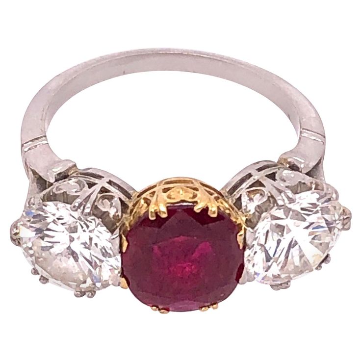 Two Tone Gold Three Stone Large Burma Myanimar Ruby Double Diamond Dinner Ring. Having a large and impressive bright ruby red center stone set in yellow gold flanked by two diamonds set in white gold each weighing approximately 1.60 carat. The Transparent Ruby Red stone complete with an AGL report dated December 10, 2020 document number 1111550, stating the stone is Bruma (Myanimar) non heated measuring 8.66 by 7.4 by 2.78 mm. . Luxury Antique Ruby Ring With Bezel Setting, Luxury Red Diamond Ring With Round Band, Luxury Gold Ruby Ring With Center Stone, Luxury Ruby Ring With Round Stone For Anniversary, Luxury Ruby Ring With Bezel Setting For Wedding, Luxury Vintage Ruby Ring With Center Stone, Luxury Multi-stone Unique Ruby Ring, Luxury Ruby Wedding Ring With Round Stone, Luxury Multi-stone Ruby Ring As Gift