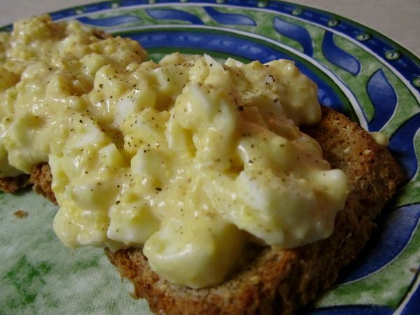 two pieces of bread with macaroni and cheese on it sitting on a plate