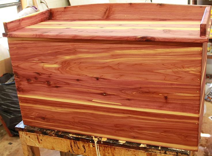 a large wooden box sitting on top of a piece of wood in a room filled with other items