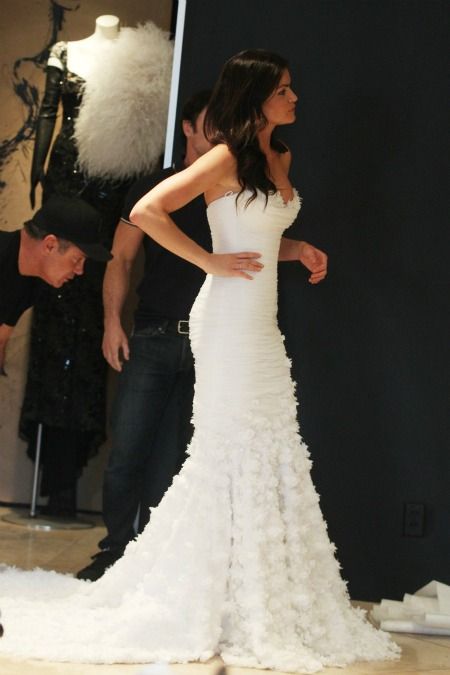 a woman in a white dress standing next to a man