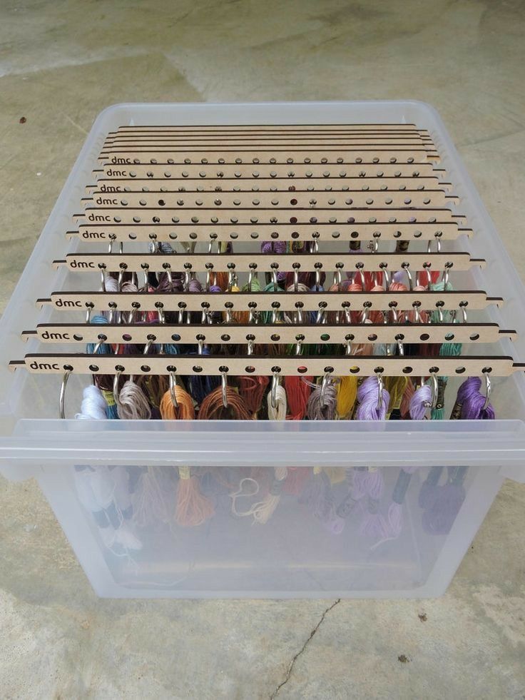 a plastic container filled with lots of different colored thread