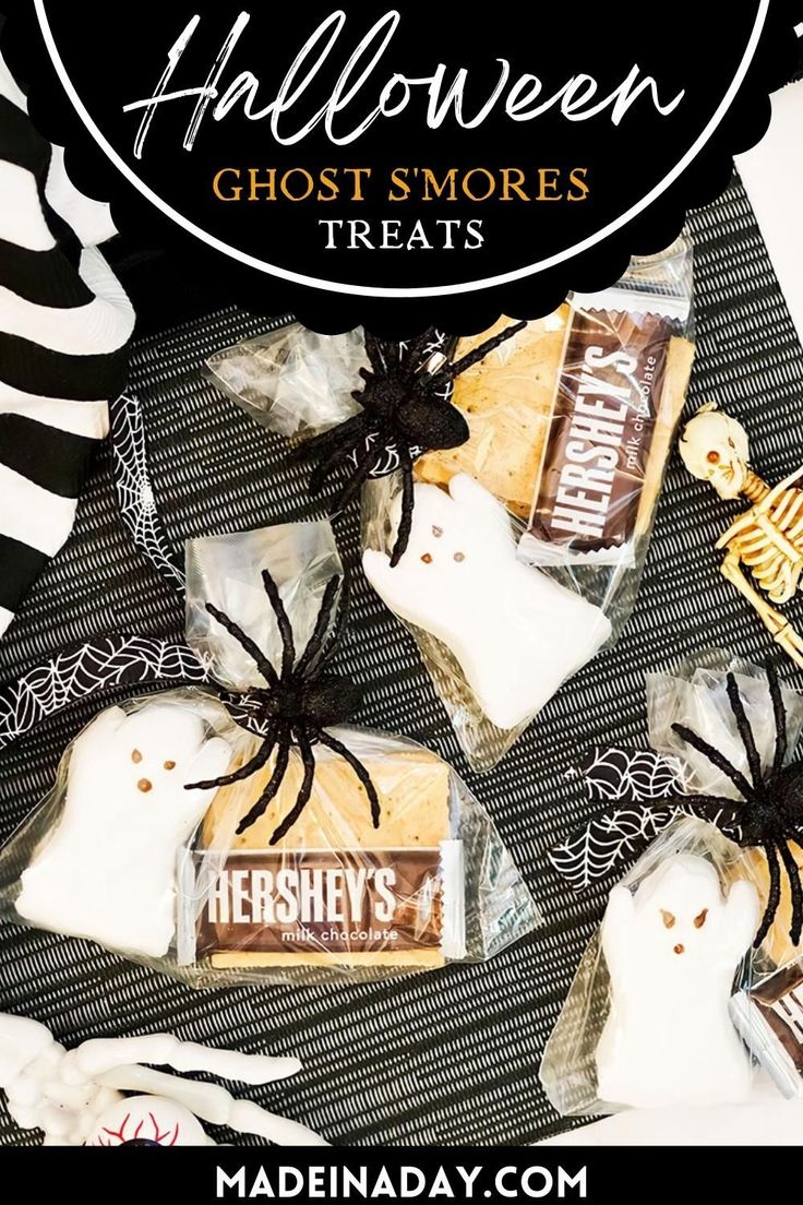 halloween ghost s'mores treats on a table with black and white striped cloth