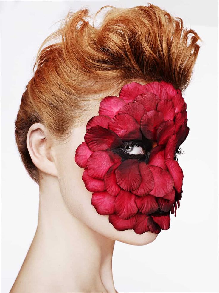 a woman with red flowers painted on her face