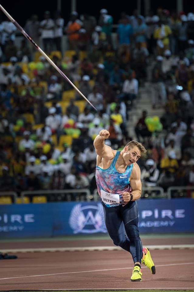 a man is throwing a stick in the air at an outdoor track and field event