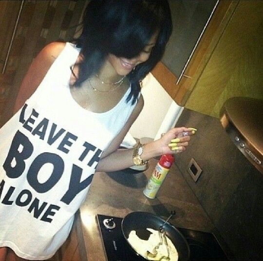 a woman standing in front of a stove with food on the burner next to her