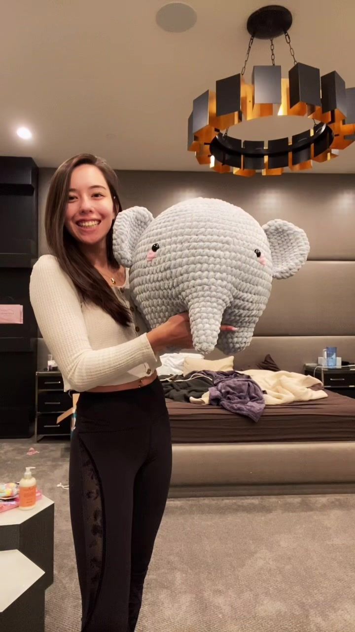 a woman holding an elephant made out of legos