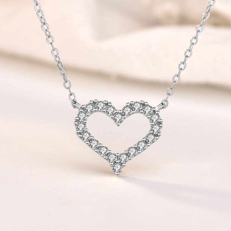 This exquisite piece embodies a perfect blend of elegance and sophistication. Crafted with utmost precision, the heart-shaped pendant is made from sterling silver, radiating a timeless charm. The round cut stones glisten with a captivating brilliance, adding a touch of enchantment to your every ensemble. Wear this mesmerizing necklace as a symbol of love and purity, embracing its graceful beauty close to your heart.Weight: 2.2 gWidth: 15 mmHeight: 13 mmMaterial: 925 SilverPlating Color: SilverLe Cubic Zirconia Heart Necklace For Wedding, Elegant Double Heart Cubic Zirconia Necklace, Formal Heart Cut Cubic Zirconia Necklace, Crystal Double Heart Necklaces For Wedding, Crystal Double Heart Jewelry For Wedding, Cubic Zirconia Heart Charm Jewelry For Wedding, Cubic Zirconia Heart Pendant Jewelry For Wedding, Elegant Heart Charm Jewelry With Cubic Zirconia, Elegant Heart Charm Jewelry In Cubic Zirconia