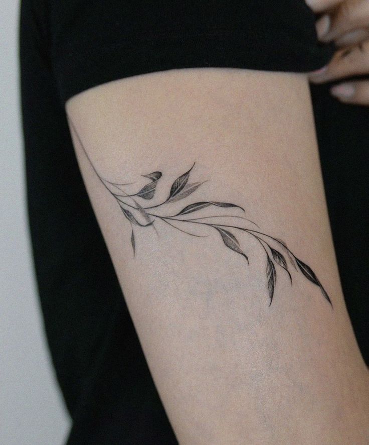 a woman's arm with a small tattoo design on the left side of her body