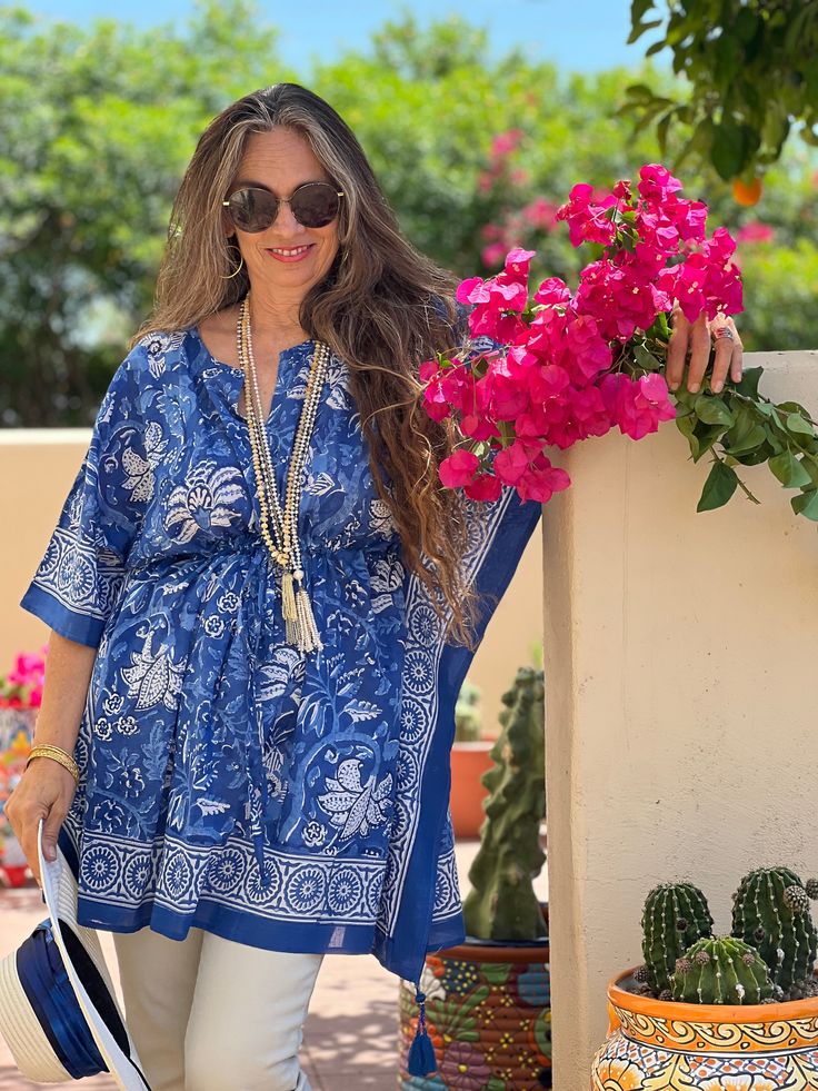 Our Delfina midi kaftan dress makes the perfect statement piece for your wardrobe in any season. The colours in this print represent the bluest of blues, and are reminiscent of the Greek Isles for sure. We called it Delfina as it is represents all that is good, classy, and pure. Wear this dress and you will enjoy a real delfina lifestyle for sure. Tassels are hand made and fabric of course is hand printed. Coming soon also in maxi and short. Length 32" One size, with adjustable drawstring waist Chic Blue Tunic For Spring, Blue Tunic With Kimono Sleeves For Summer, Summer Blue Flowy Kaftan, Blue Flowy Kaftan For Summer, Blue Floral Print Beach Tunic, Blue Tunic With Kimono Sleeves, Blue Floral Print Tunic For The Beach, Blue Tunic With Kimono Sleeves For Spring, Flowy Blue Summer Tunic