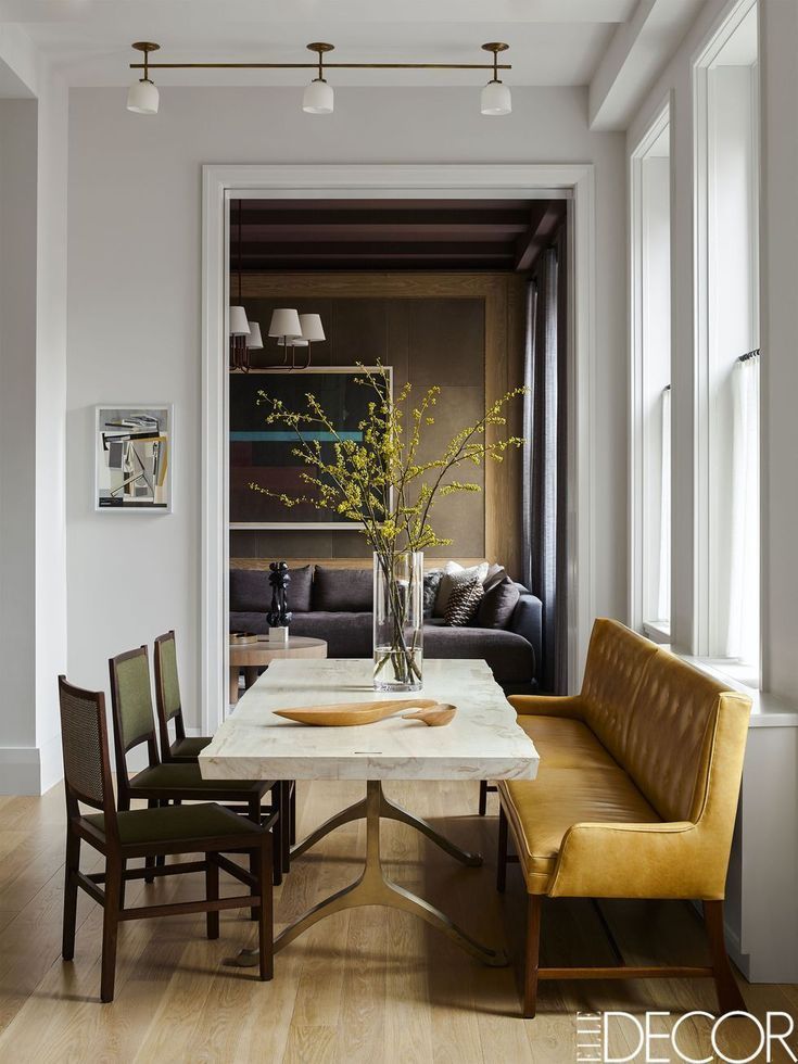 a dining room table with two chairs and a bench in front of the couches