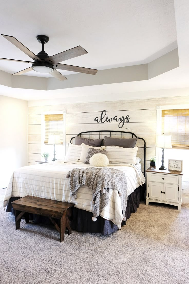 a bedroom with a bed, nightstands and ceiling fan in the middle of it