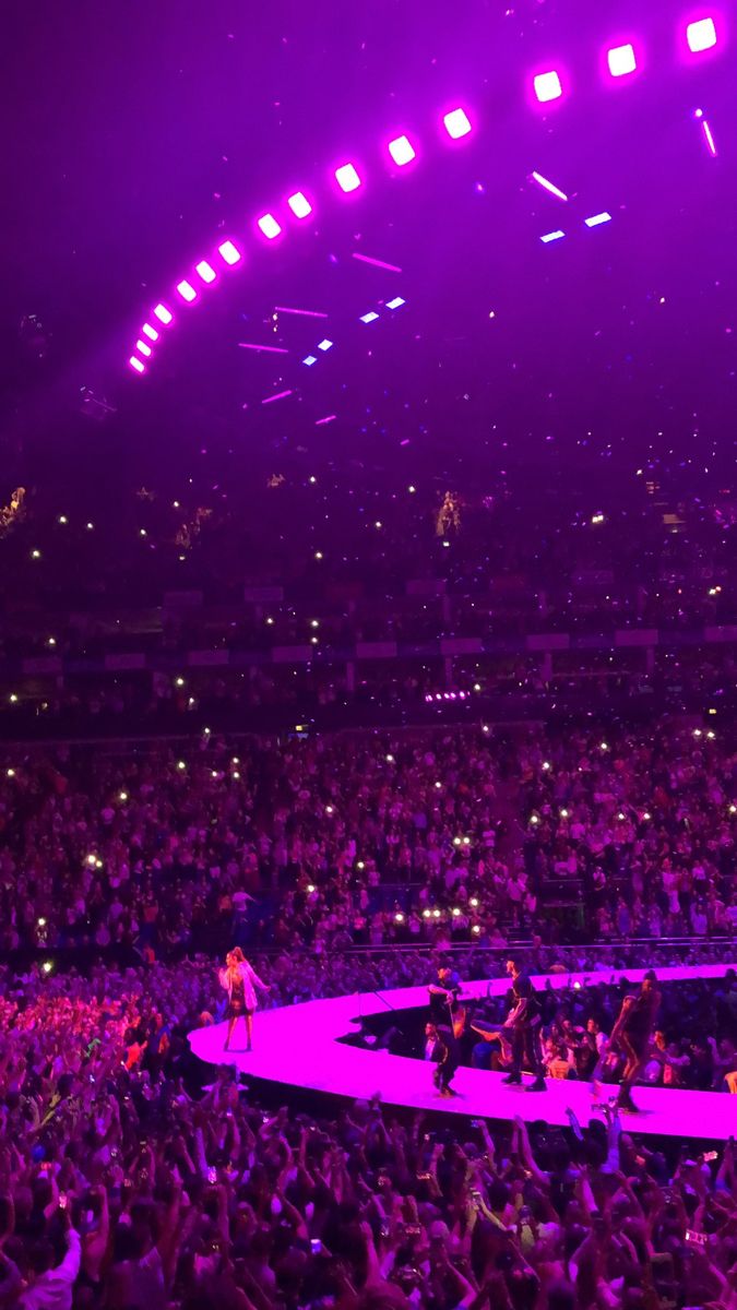 an audience at a concert with purple lighting