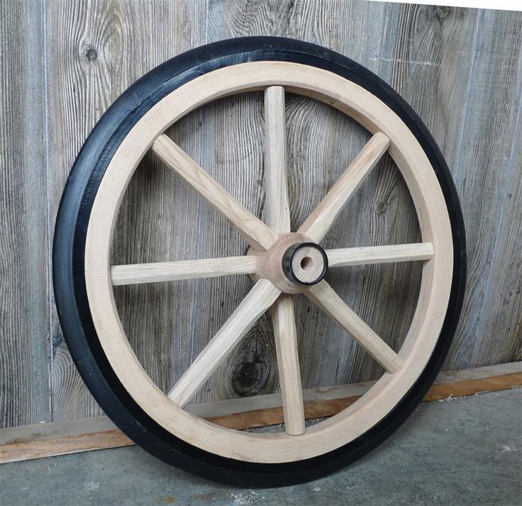 an old wooden wheel on the side of a building